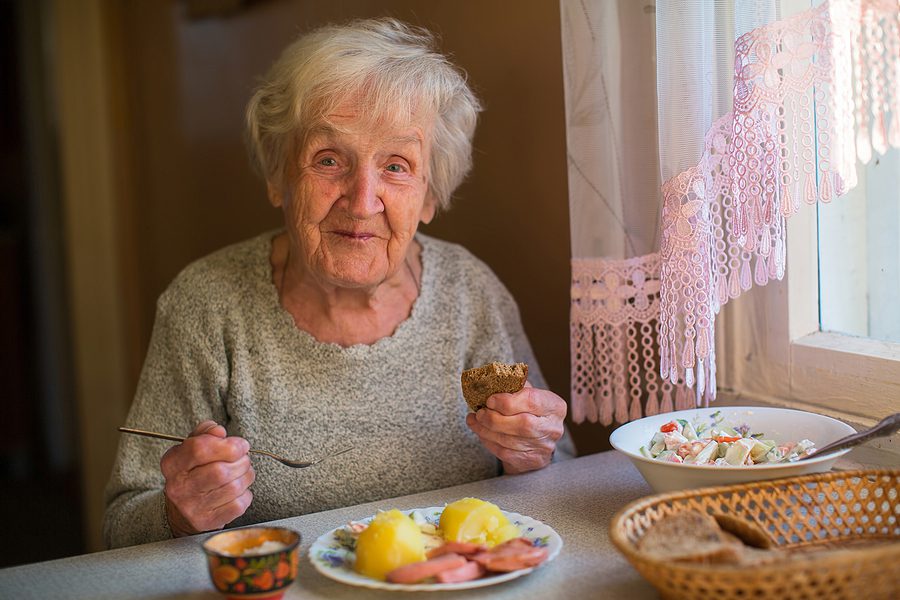 Older woman eating at home at the table. Martha